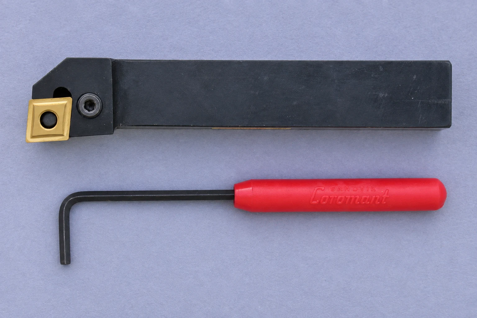Turning holder and adjustment key photographed on slate paper; photo-based editorial edit
