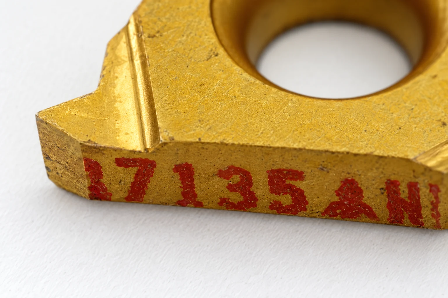 Close view of engraved identification on a threading insert; photo-based editorial edit