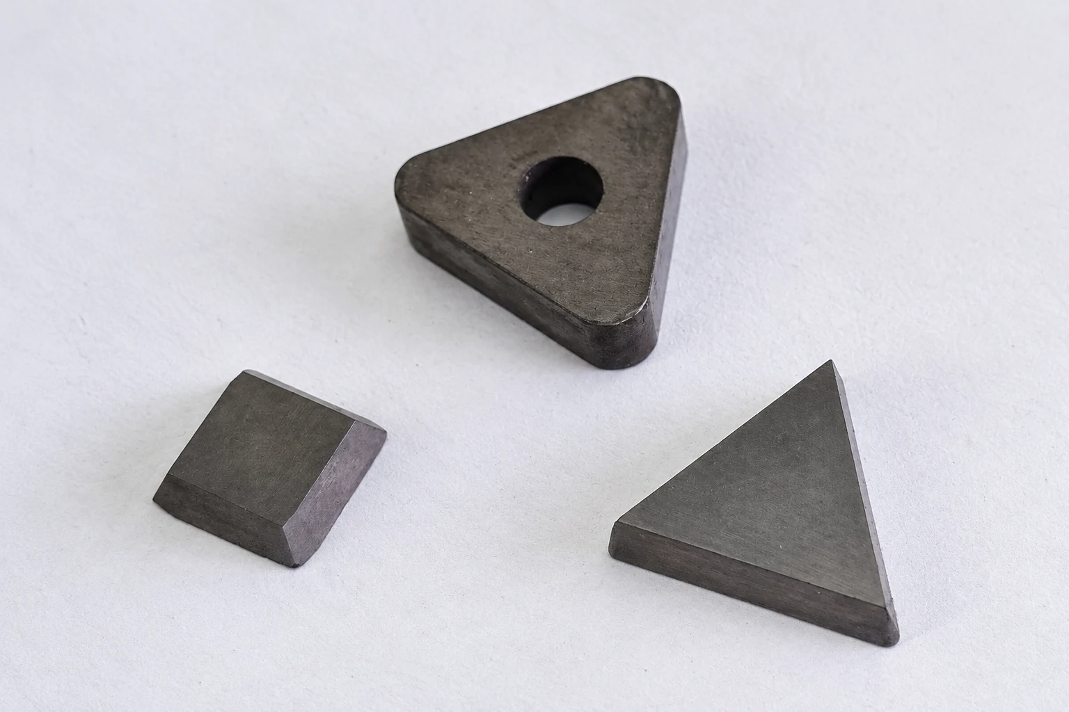 Three photographed carbide pieces with different shapes; photo-based editorial edit