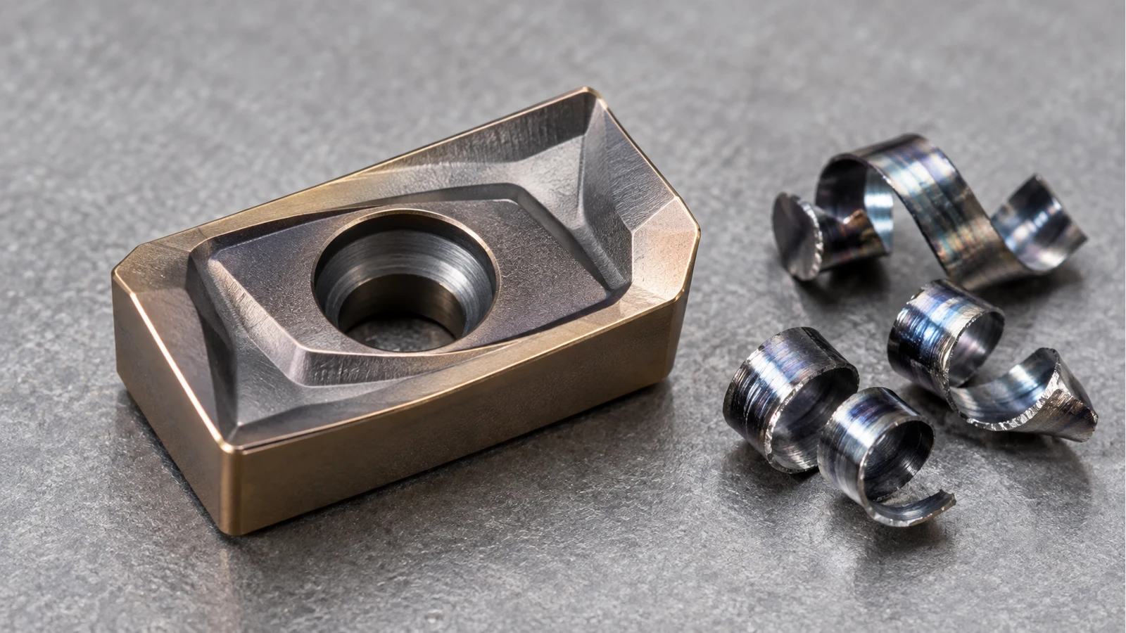 Milling insert clamping hole and chipbreaker beside curled chips