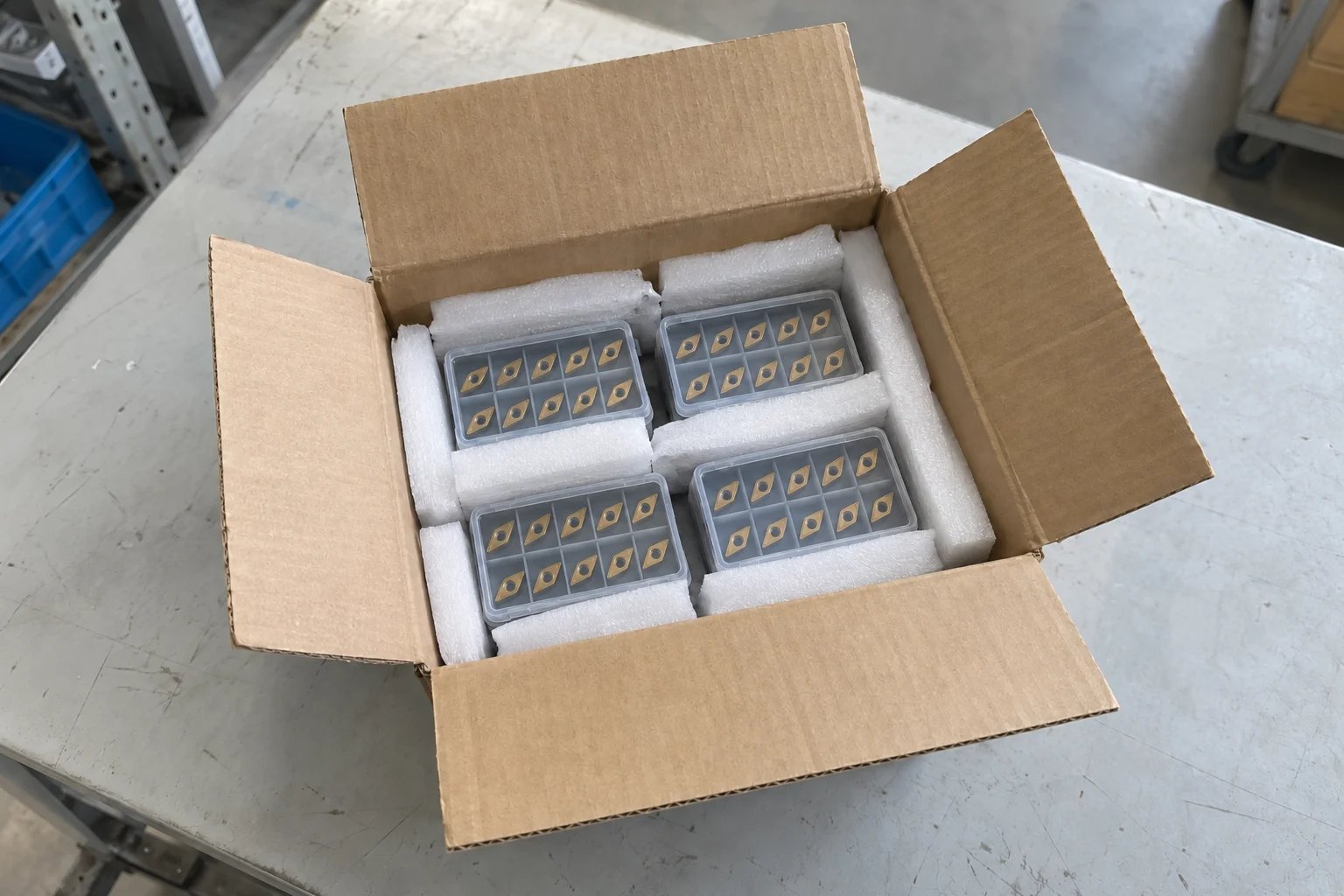 Four plastic insert boxes separated by protective foam inside a shipping carton